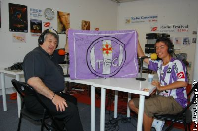 Michel et Julien présentent le drapeau dédicacé du TFC.